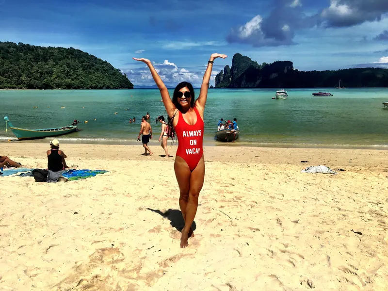 Vania on a beach with longtail boats and limestone cliffs in Thailand